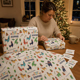 A woman is sitting at a table, wrapping presents with a festive Christmas theme. She is surrounded by various wrapped gifts, each with a unique design, including a pattern of llamas and other animals. The scene is set against a backdrop of a decorated Christmas tree, creating a warm and joyful atmosphere.