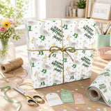 a birthday gift wrapped in a white paper with green polka dots and a brown bow, placed on a wooden table. There are also some craft supplies, such as scissors and confetti, and a vase of flowers nearby.