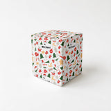 A white gift box with a pattern of Christmas-themed icons and text on it.