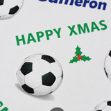 a close-up of a soccer ball and a holly leaf, with the text "HAPPY XMAS" displayed prominently.