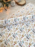 a roll of wrapping paper with a repeating pattern of brown hedgehog faces and the text "Merry Christmas Jane" printed on it.