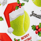 A close-up of a Christmas-themed image with a Santa hat, holly leaves, and a tennis ball.
