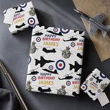 a birthday gift wrapped in a pattern with military aircraft silhouettes and the text "Happy Birthday James" printed on it.