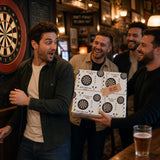 A group of men are gathered around a dartboard in a bar, with one man holding a package with a dartboard design.
