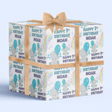 A gift box with a bow, featuring a repeating pattern of the name "Noah" and the phrase "Happy 1st Birthday Noah" on it.