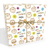 The image is a gift box with a pattern of cartoon hedgehog faces and flowers on it. The box is tied with a string and has the text "Happy Birthday Felix" printed on it.