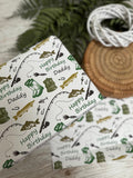 a gift box with a fishing-themed wrapping paper, along with some other items such as a wicker basket and a coiled rope.