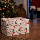 A Christmas tree with twinkling lights, a Santa Claus ornament, and a gift box with a Santa Claus design.