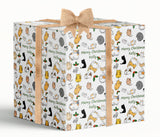 A large gift box with a white background and a pattern of cats and other animals printed on it. The gift box has a burlap bow tied around it.