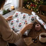 A person is wrapping a gift with a patterned wrapping paper featuring a dartboard design, surrounded by festive decorations and a Christmas tree.