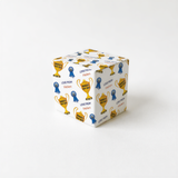 A white gift box with a repeating pattern of yellow and blue trophies and ribbons on its surface.