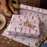 a birthday gift wrapped in pink paper with a repeating pattern of silhouettes of people and horses, along with the text "Happy Birthday Sophie". The gift is placed on a wooden surface, and there are cowboy boots and a hat nearby.