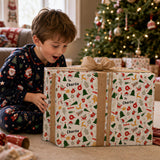 A young boy in pajamas is excitedly opening a large, patterned gift box with a bow, surrounded by Christmas decorations and a decorated tree in the background.