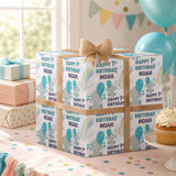 A birthday gift box with a bow, surrounded by birthday decorations, balloons, and a cupcake on a table.