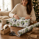 A woman is wrapping a gift box with a patterned wrapping paper featuring rugby-related designs.