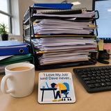 a cluttered office desk with a coffee mug, a keyboard, and a coaster with a cartoon image of a person sleeping at a desk.