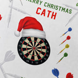 A close-up of a dartboard with a Santa hat on top, surrounded by colorful dart arrows and a "Merry Christmas Cath" greeting.