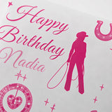The image is a birthday card with a pink silhouette of a person holding a lasso, surrounded by stars and a horseshoe. The card has the text "Happy Birthday Nadia" written on it.