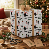 A gift box wrapped in a festive paper with a Christmas tree in the background, along with some holiday decorations and a pair of scissors on a wooden surface.